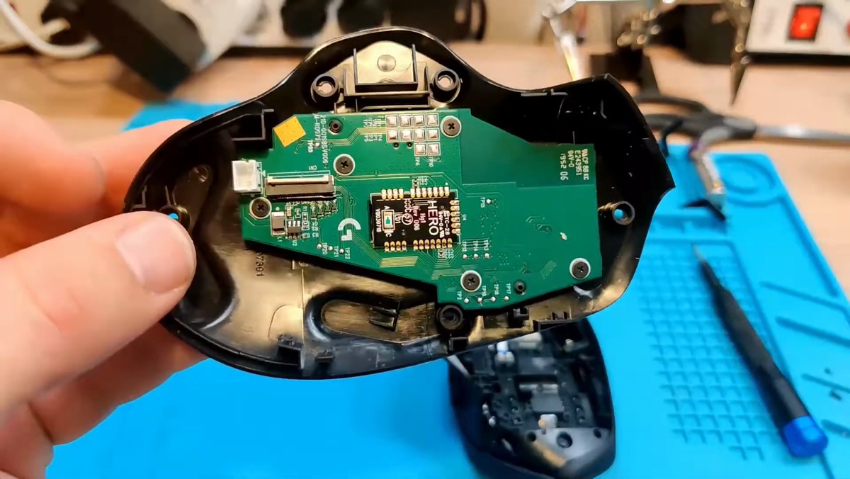 Bottom of Logitech G604 with screws being removed using a precision screwdriver